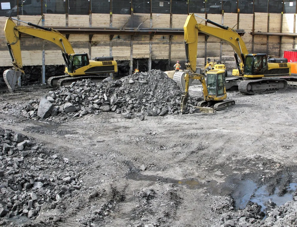 Excavators working across a large commercial demolition site
