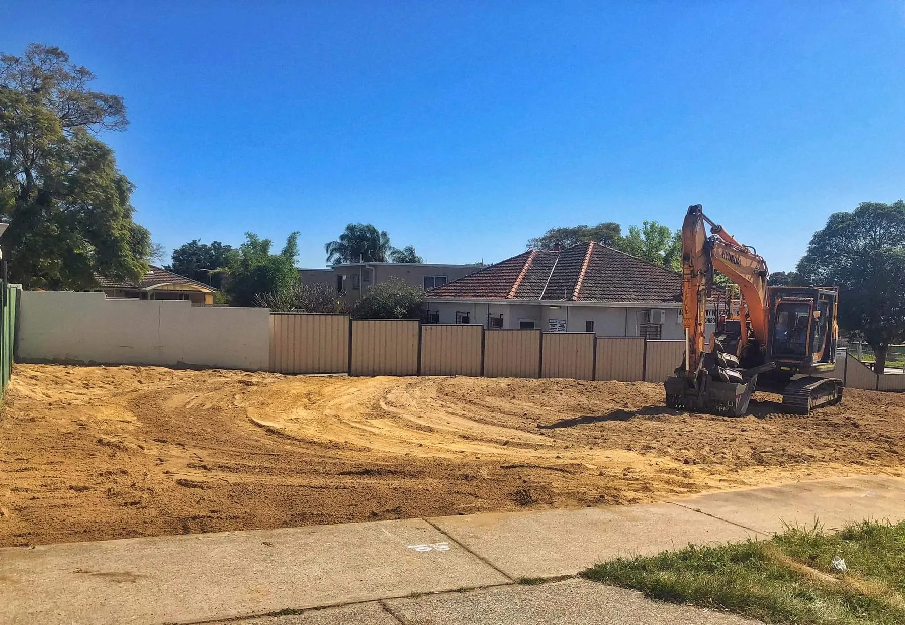 Cleared building block with an excavator ready for site preparation