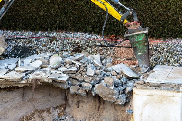 on a private swimming pool construction is dismantled by an excavator